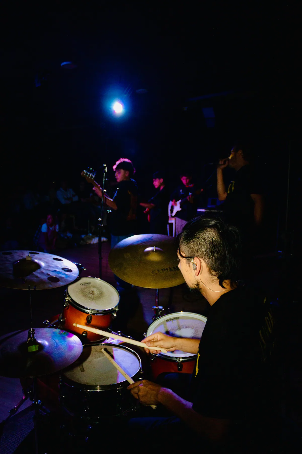 Baterista visto desde atrás durante una presentación.