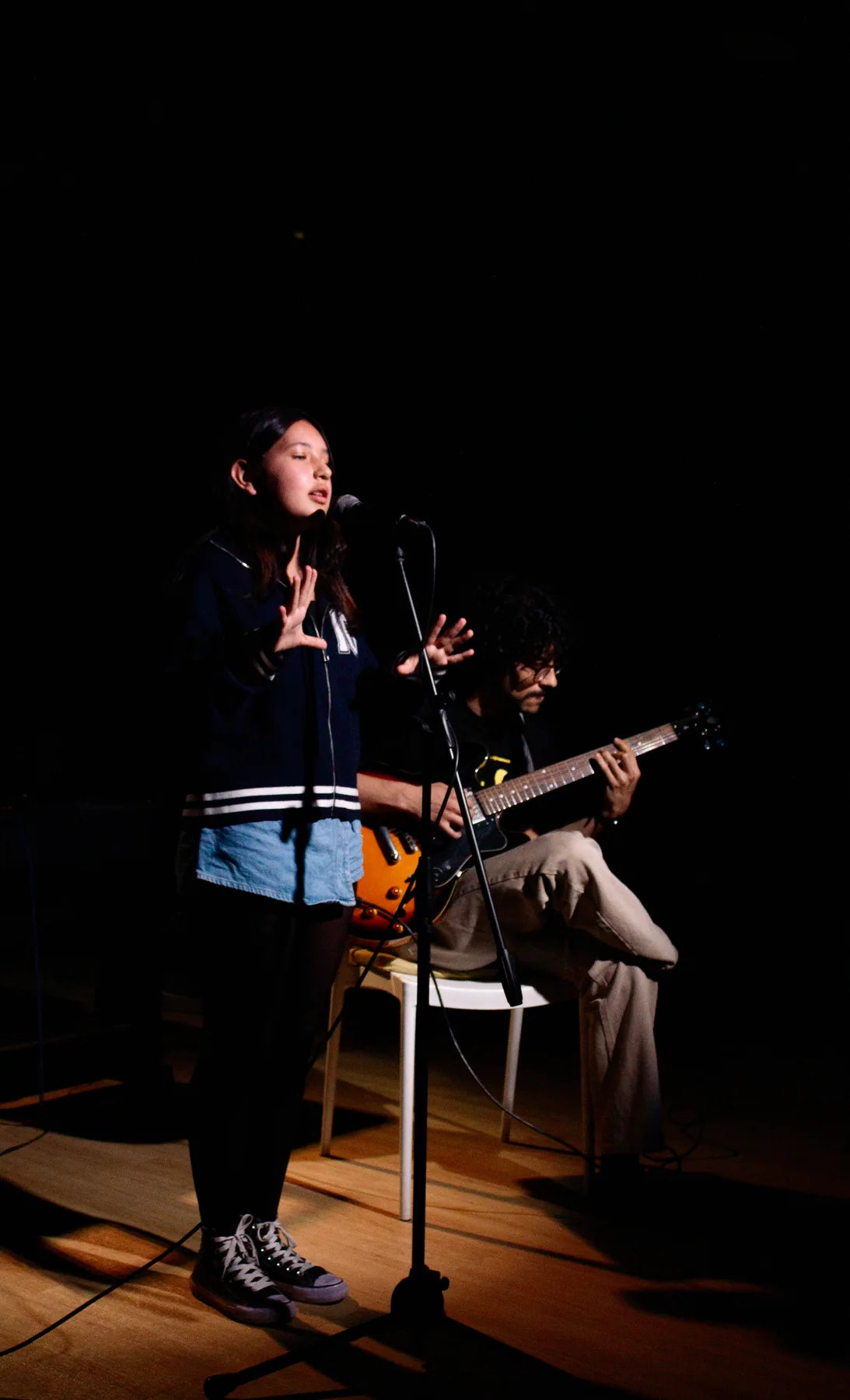 Cantante con guitarra interpreta una canción en el escenario.